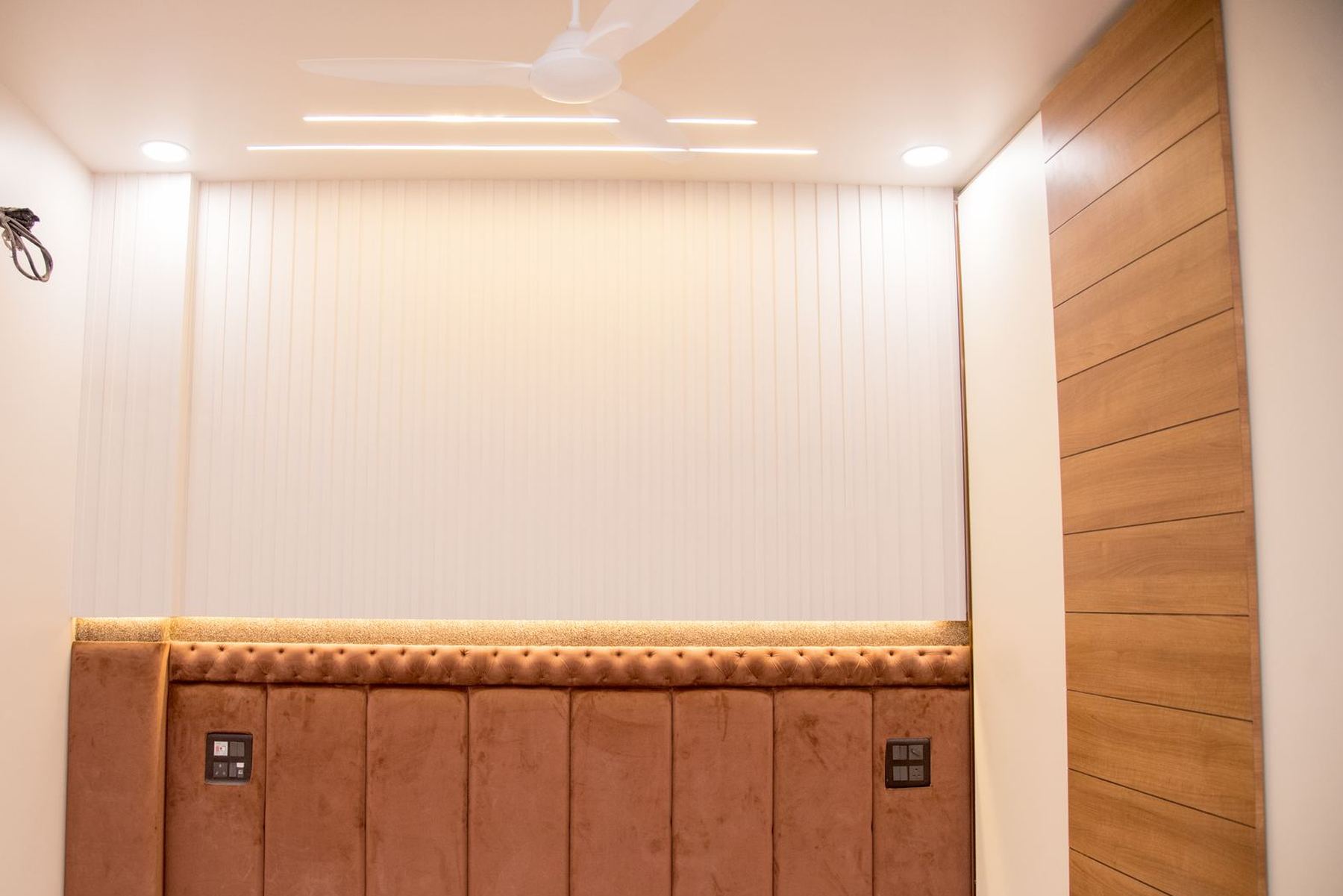 Bedroom with upholstered headboard wall and wooden cladding