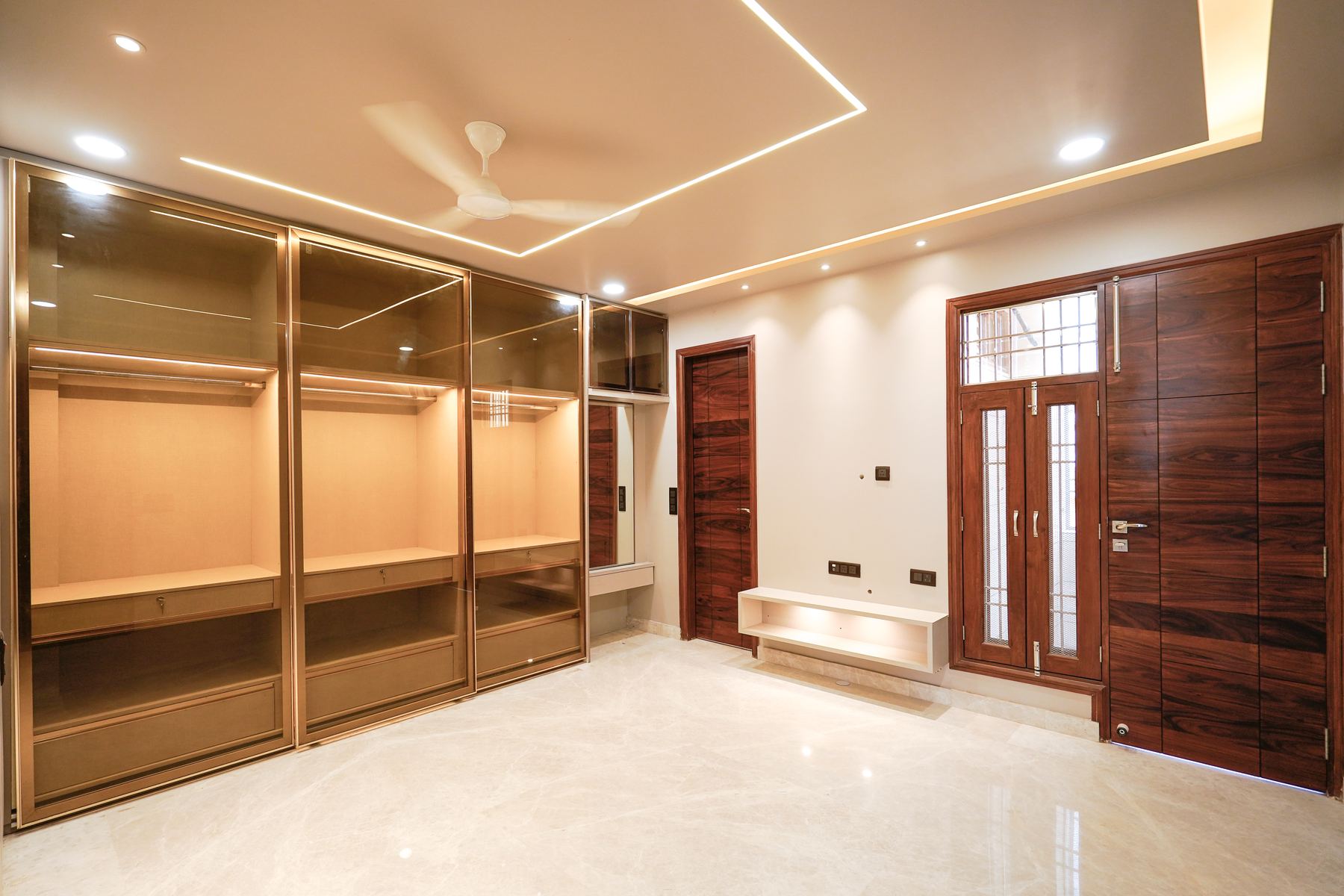Master bedroom with glass-front walk-in wardrobe and lit false ceiling